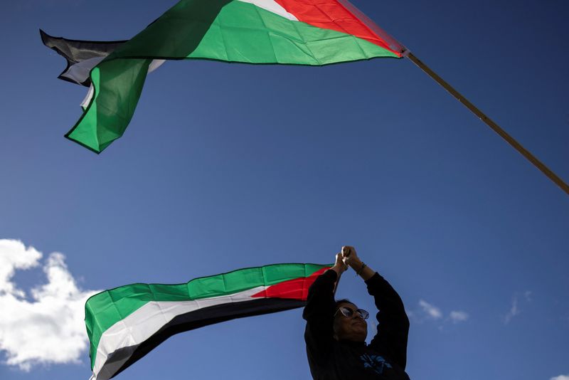© Reuters. FILE PHOTO: A woman holds a flag of Palestine during a rally held in support of Palestinians amid the ongoing conflict between Israel and the Palestinian Islamist group Hamas, in Mineola, New York, U.S., October 15, 2023. REUTERS/Andrew Kelly/File photo