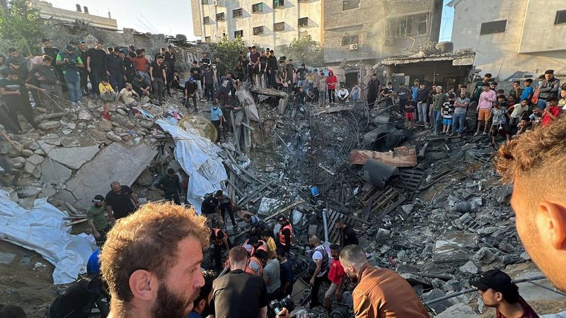 &copy; Reuters. Palestinos se reúnen en el lugar de un ataque israelí contra una casa, en medio del actual conflicto entre Israel y el grupo islamista palestino Hamás, en la ciudad de Gaza. 21 de octubre de 2023. REUTERS/Mutasem Murtaja