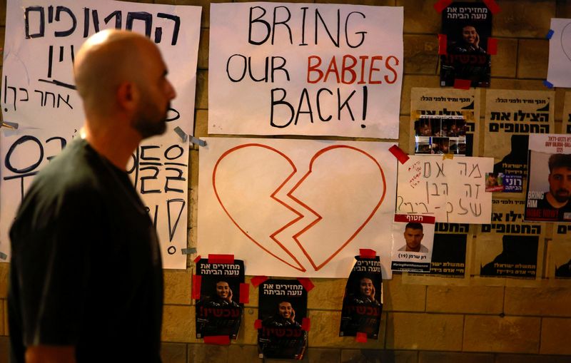 &copy; Reuters. A person looks at posters depicting hostages and missing people, as residents of Tel Aviv show support and solidarity with the families of hostages who are being held in Gaza, amid the ongoing conflict between Israel and Hamas, in Tel Aviv, Israel, Octobe