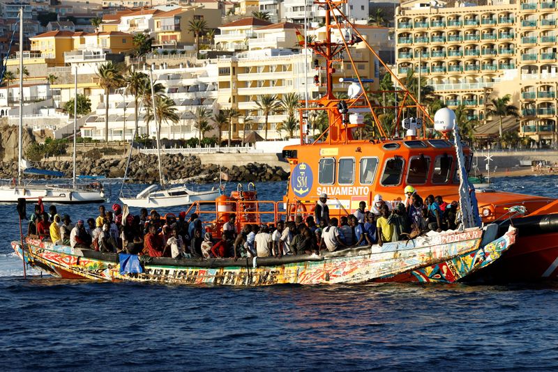 &copy; Reuters. A group of migrants in a wooden boat are towed by a Spanish coast guard vessel to the port of Arguineguin, in the island of Gran Canaria, Spain, October 21, 2023. REUTERS/Borja Suarez