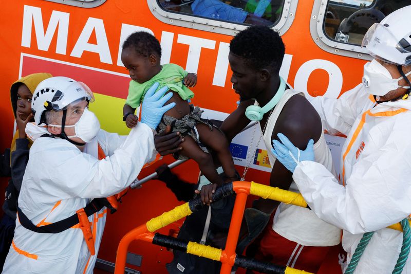 © Reuters. Rescuers disembark a migrant baby from a Spanish coast guard vessel, in the port of Arguineguin, on the island of Gran Canaria, Spain, October 21, 2023. REUTERS/Borja Suarez