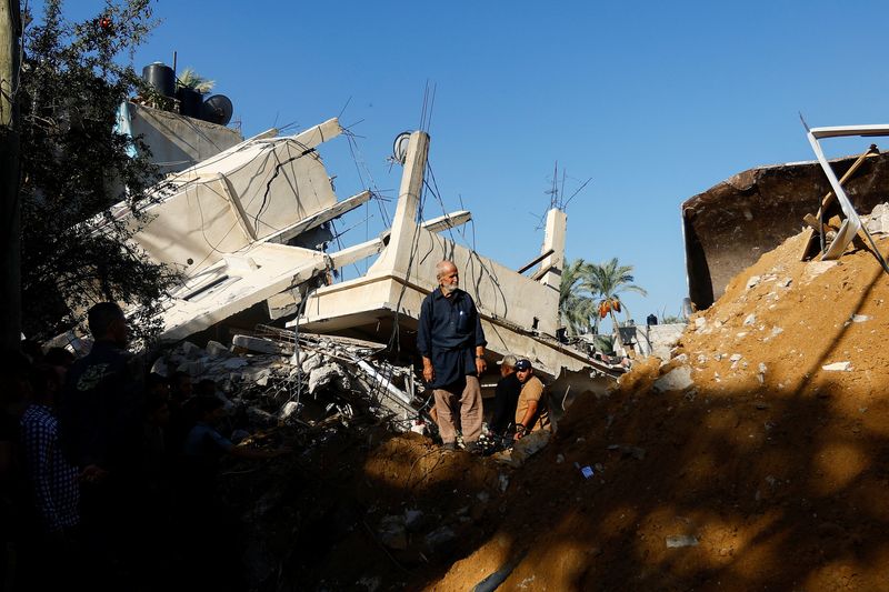 © Reuters. فلسطينيون يبحثون عن ضحايا في موقع لغارة إسرائيلية على منزل بخان يونس في جنوب قطاع غزة يوم 21 أكتوبر تشرين الأول 2023. تصوير: إبراهيم أبو مصطفى - رويترز.
