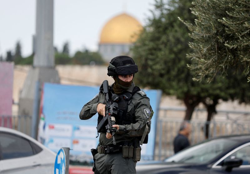 &copy; Reuters. أحد أفراد شرطة الحدود الإسرائيلية يقف للحراسة بينما يحضر الفلسطينيون صلاة الجمعة خارج البلدة القديمة في القدس يوم 20 أكتوبر تشرين الأول 2023. 