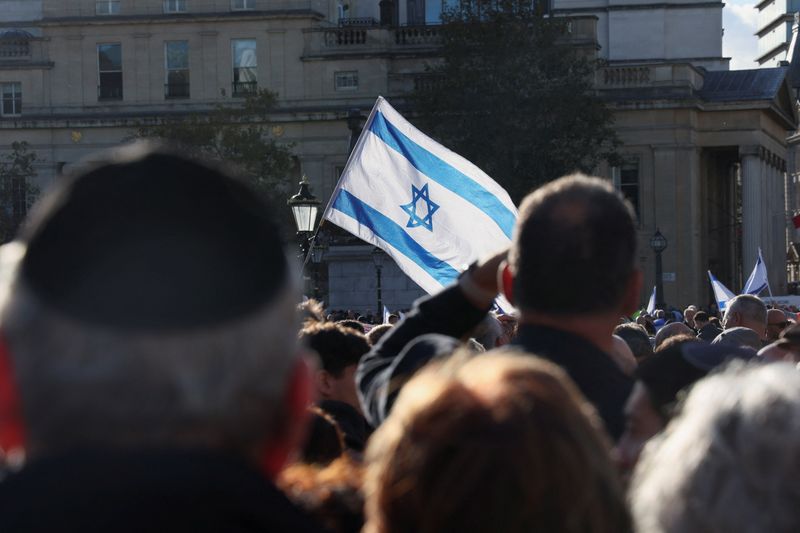 &copy; Reuters. متظاهر يلوح بالعلم الإسرائيلي بينما يتجمع الآلاف خلال احتجاجات  للمطالبة بإفراج حماس عن الرهائن في لندن يوم الأحد. تصوير: يان تيسييه- رويترز