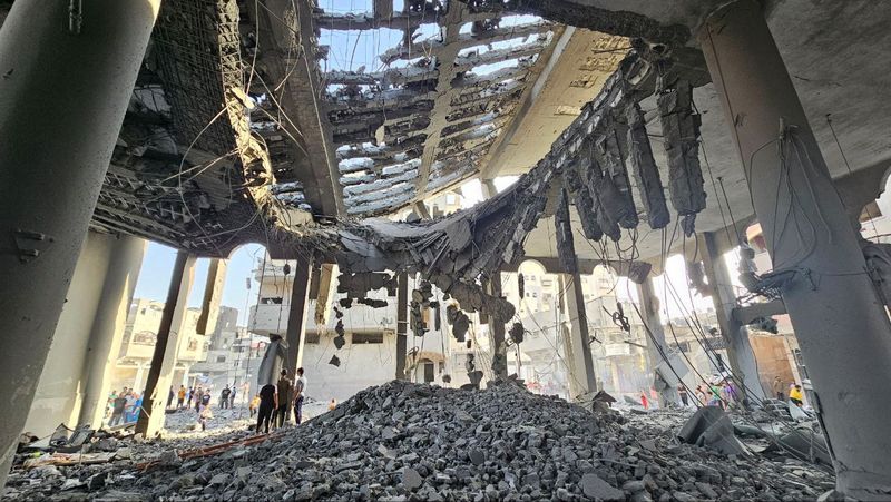 &copy; Reuters. سكان فلسطينيون يتفقدون آثار الدمار التي لحقت بمسجد في شمال قطاع غزة جراء تعرضه لضربات جوية إسرائيلية يوم الأحد . تصوير : أنس الشريف - رويترز . 