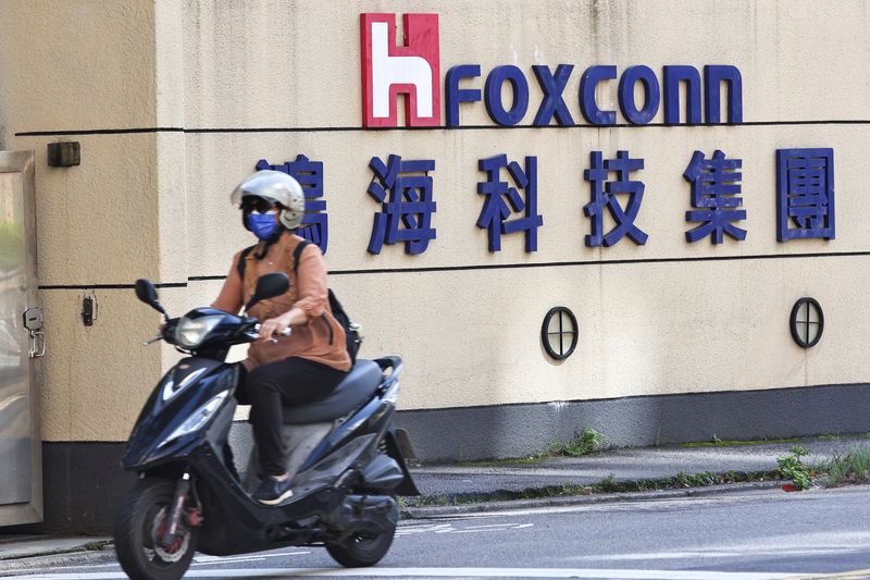 &copy; Reuters. FILE PHOTO: A woman drives past the logo of Foxconn outside the company's building in Taipei, Taiwan November 9, 2022. REUTERS/Ann Wang/File Photo