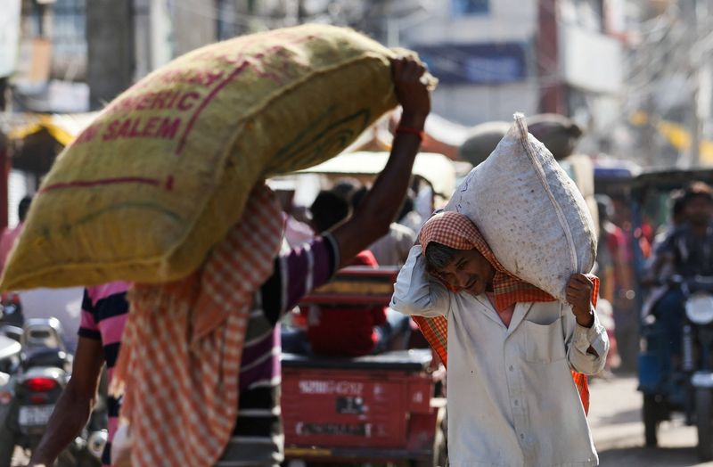 &copy; Reuters. FILE PHOTO: A labourer carries a sack at a wholesale market in the old quarters of Delhi, India, June 7, 2023. REUTERS/Anushree Fadnavis/File photo
