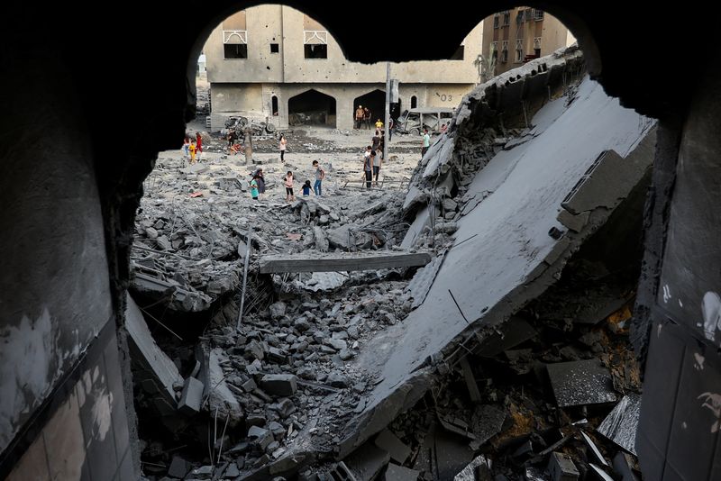 &copy; Reuters. Palestinos inspeccionan el lugar de los ataques israelíes contra una casa en Jan Yunis, en el sur de la Franja de Gaza, 23 de octubre de 2023. REUTERS/Ibraheem Abu Mustafa