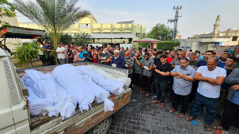 © Reuters. أشخاص يحضرون جنازة فلسطينيين قتلوا في ضربات إسرائيلية بشمال قطاع غزة يوم الاثنين. تصوير: أنس الشريف - رويترز.
