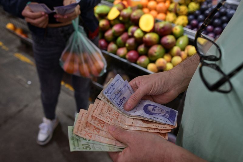 &copy; Reuters. A customer counts Venezuelan Bolivar notes at a stall in a municipal market in Caracas, Venezuela February 10, 2023. REUTERS/Gaby Oraa