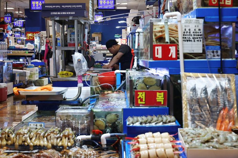 &copy; Reuters. FILE PHOTO: A shopkeeper waits for customers at Noryangjin fisheries wholesale market in Seoul, South Korea, July 6, 2023.  REUTERS/Kim Hong-Ji/File photo