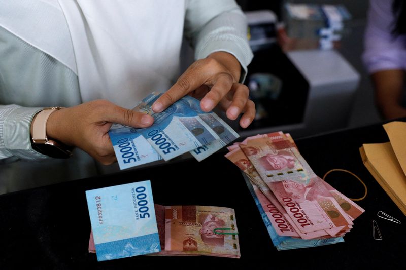 &copy; Reuters. FILE PHOTO: A teller counts Indonesian rupiah bank notes at a money changer in Jakarta, Indonesia, October 14, 2022. REUTERS/Willy Kurniawan/File Photo