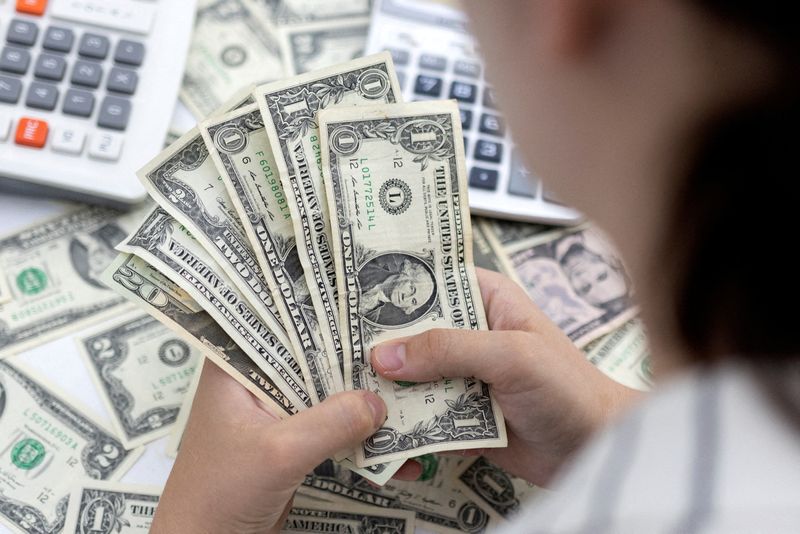 &copy; Reuters. Una donna conta diverse banconote da un dollaro. 30 maggio 2022. REUTERS/Dado Ruvic/Illustration/File Photo
