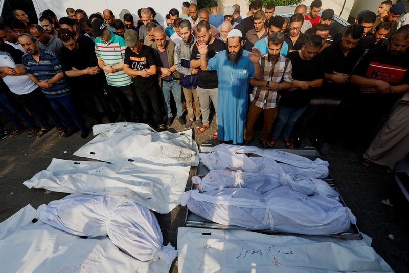 © Reuters. أشخاص خلال تشييع جنازة فلسطينيين قتلوا في غارات إسرائيلية بخان يونس في جنوب قطاع غزة يوم الثلاثاء. تصوير: محمد سالم - رويترز. 
