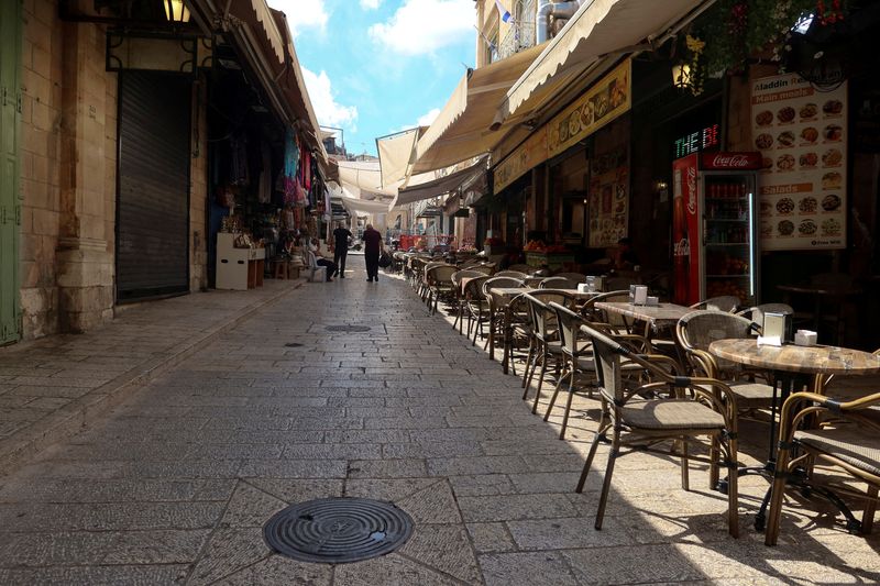 © Reuters. FILE PHOTO: People walk into Jerusalem's Old City via Jaffa Gate, as the conflict wreaks havoc across the tourism sector October 11, 2023. REUTERS/Sinan Abu Mayzer/File Photo