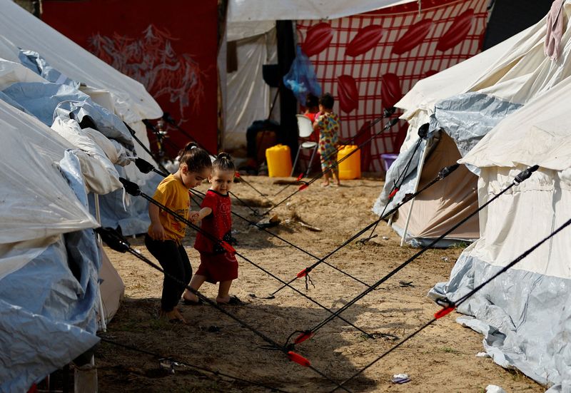 &copy; Reuters. Niños palestinos desplazados, que huyeron de sus casas en medio de los ataques israelíes, se refugian en un campamento de tiendas de campaña en un centro gestionado por las Naciones Unidas, tras el llamamiento de Israel para que más de un millón de c