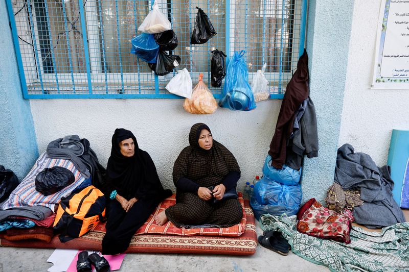 &copy; Reuters. سيدتان فلسطينيتان يجلسان في مدرسة تابعة للأمم المتحدة، بعد أن فرتا من شمال غزة جراء تحذيرات من الجيش الإسرائيلي، في خان يونس بقطاع غزة الجن