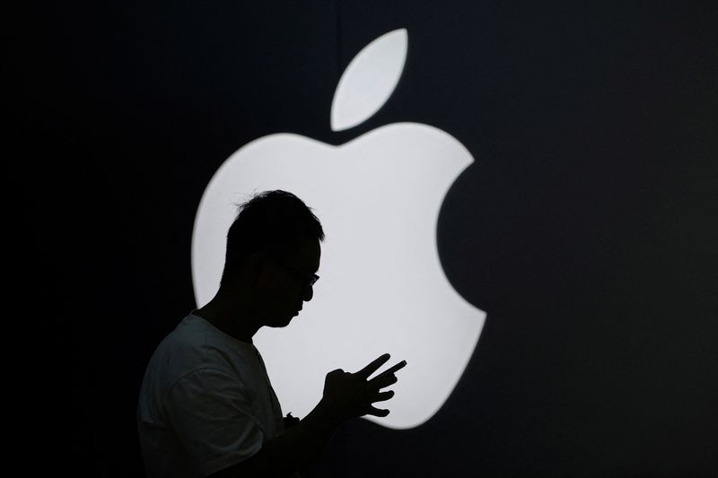 &copy; Reuters. A man check his phone near an Apple logo outside its store in Shanghai, China September 13, 2023. REUTERS/Aly Song/File photo