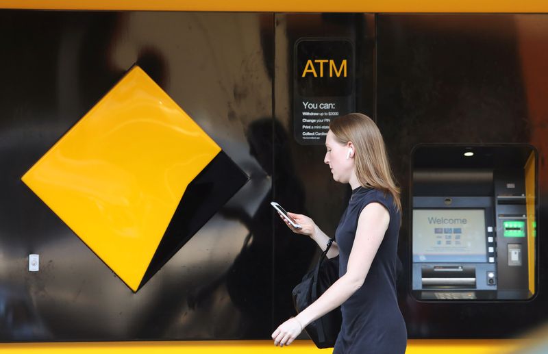 &copy; Reuters. FILE PHOTO:A woman walks past a Commonwealth Bank of Australia logo and ATM in Sydney, Australia, February 7, 2018. REUTERS/Daniel Munoz/File Photo