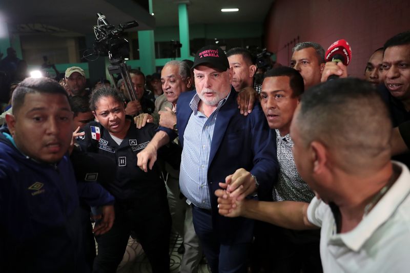 &copy; Reuters. Panama's former president Ricardo Martinelli is escorted by police officers and supporters while leaving a courthouse after being declared not guilty of spying charges in Panama City, Panama August 9, 2019. Martinelli's cap reads, "I survived Varela", ref