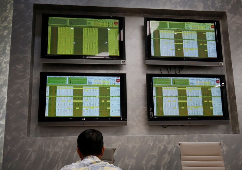 &copy; Reuters. FILE PHOTO: An investor sits in front of screens showing stock board information at a securities company in Hanoi, Vietnam July 6, 2018. Picture taken July 6, 2018. REUTERS/Kham/File photo