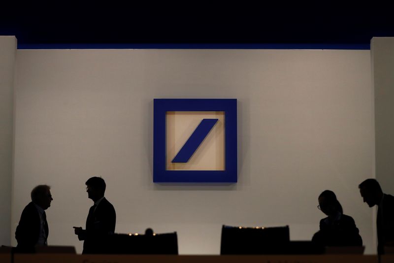 © Reuters. People are silhouetted next to the Deutsche Bank's logo prior to the bank's annual meeting in Frankfurt, Germany, May 24, 2018. REUTERS/Kai Pfaffenbach