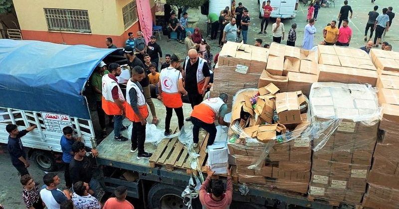 &copy; Reuters. Members of the Palestine Red Crescent Society distribute aid to people in Deir al-Balah, in the central Gaza Strip, in this handout picture released on October 25, 2023.  Palestine Red Crescent Society/Handout via REUTERS