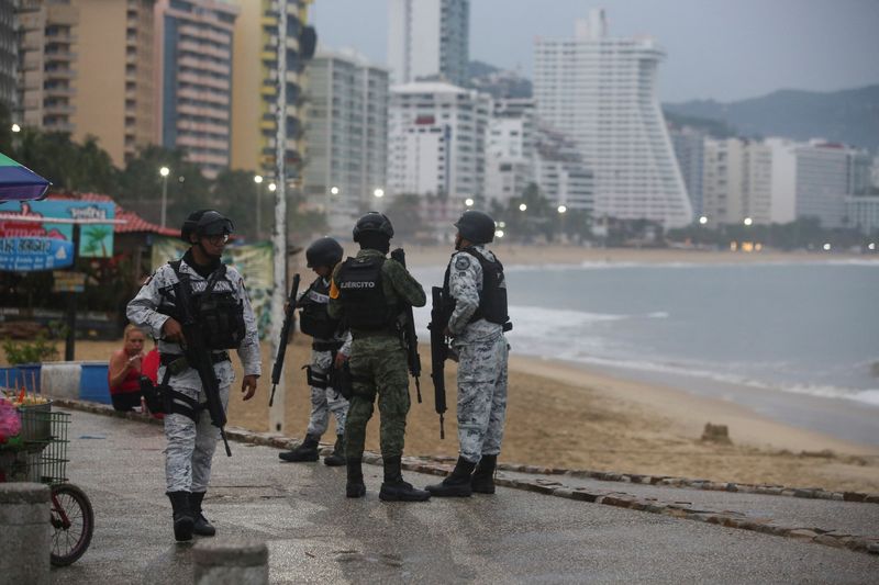 © Reuters. Miembros de las fuerzas federales charlan mientras vigilan en una playa a medida que el huracán Otis se acerca a Acapulco, México, 24 de octubre de 2023. REUTERS/Javier Verdin