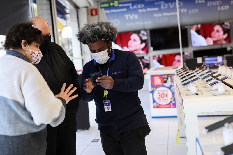 &copy; Reuters. Vendedor mostra telefone celular para consumidor em loja em São Paulo
03/08/2021 REUTERS/Amanda Perobelli