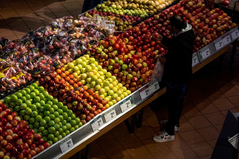 &copy; Reuters. FILE PHOTO: A  man checks an apple while shopping at a grocery store in Toronto, Ontario, Canada November 22, 2022.  REUTERS/Carlos Osorio/File Photo