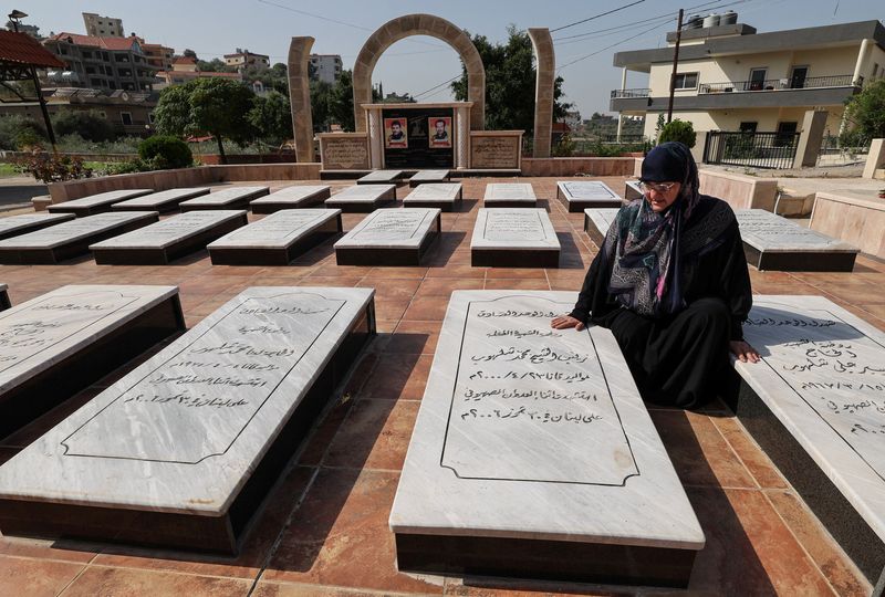 &copy; Reuters. رباب يوسف (57 عاما) إحدى الناجيات من غارة إسرائيلية قتلت العشرات عام 2006 تحلس إلى قبر ابنتها في قانا يوم الثلاثاء. تصوير: زهرة بن سمرة - رويترز 