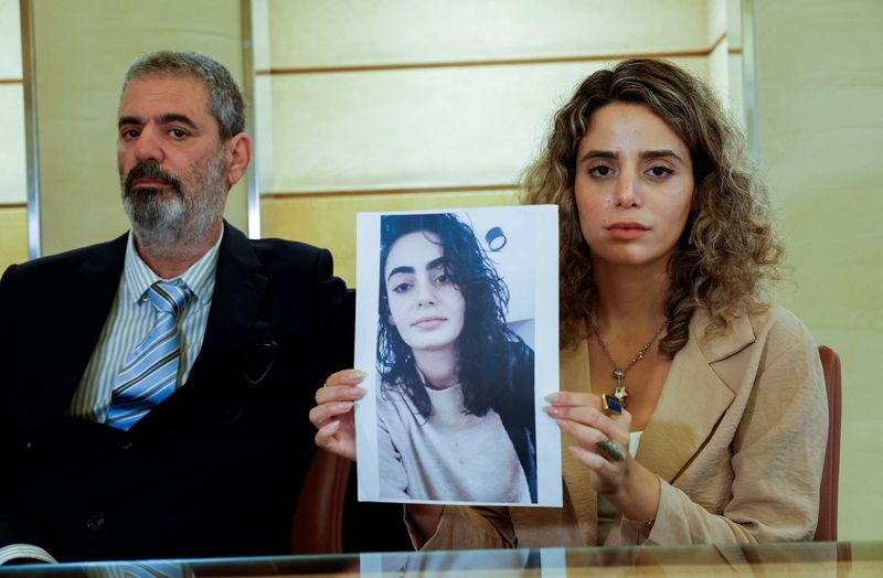 © Reuters. Adar Eylon shows a picture of her sister Shira, killed during a violent incursion by Hamas militants from Gaza, in Israel, flanked by her father Avi Eylon, during an interview with Reuters, after holding talks with Italian authorities in Rome, Italy, October 25, 2023 REUTERS/Remo Casilli