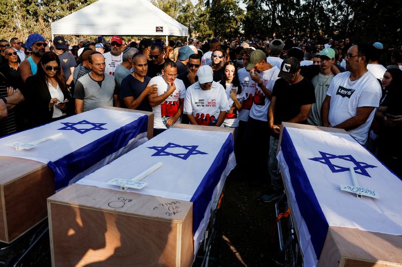 &copy; Reuters. جنازة امرأة بريطانية إسرائيلية وابنتيها في كفار هاريف يوم الأربعاء، وهن اللاتي قتلن في أعقاب الهجوم الذي شنته حركة حماس على البلدات المجاو