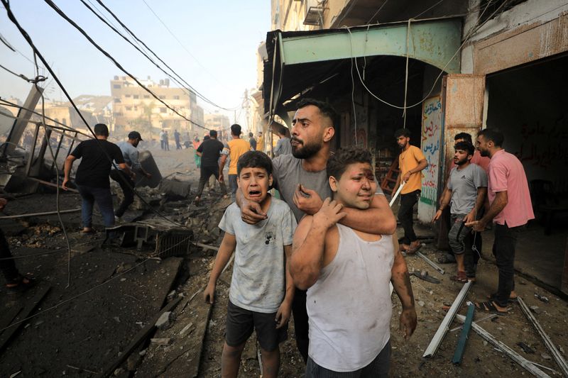 © Reuters. La gente reacciona mientras los palestinos buscan víctimas en el lugar de un ataque israelí contra un edificio residencial en la ciudad de Gaza. 25 de octubre de 2023. REUTERS/Yasser Qudih 