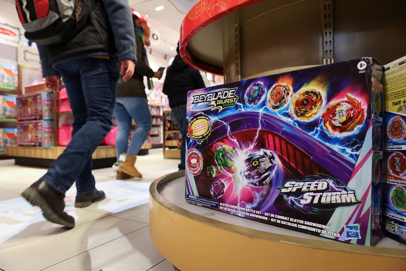 &copy; Reuters. FILE PHOTO: People walk past the Beyblade Burst Speedstorm, by Hasbro, Inc., on display in the FAO Schwarz toy store in Manhattan, New York City, U.S., November 24, 2021. REUTERS/Andrew Kelly/File photo