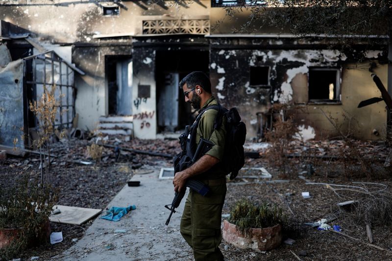 &copy; Reuters. جندي إسرائيلي يسير أمام منزل مدمر جراء هجوم نفذته حركة حماس على تجمع بييري السطني في جنوب إسرائيل يوم الأربعاء . تصوير : عمار عوض - رويترز .  