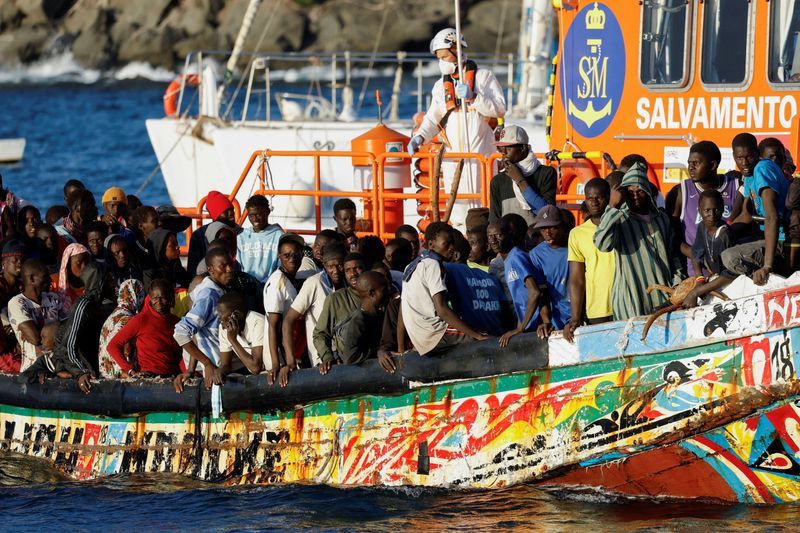 &copy; Reuters. FOTO DE ARCHIVO. Un grupo de migrantes en un bote de madera son remolcados por un barco de la guardia costera española hasta el puerto de Arguineguin, en la isla de Gran Canaria, España, el 21 de octubre de 2023.REUTERS/Borja Suarez