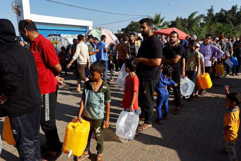 © Reuters. Palestinos, que huyeron de sus casas en medio de los ataques israelíes, hacen cola para conseguir agua mientras se refugian en un campamento de tiendas de campaña en un centro gestionado por las Naciones Unidas, en Jan Yunis, en el sur de la Franja de Gaza, el 26 de octubre de 2023. REUTERS/Ibraheem Abu Mustafa