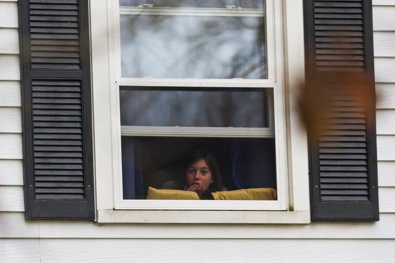 &copy; Reuters. A child looks out through a window as Lisbon Falls remains on lockdown, following a deadly mass shooting in Lewiston, in Lisbon Falls, Maine, U.S. October 26, 2023. REUTERS/Shannon Stapleton