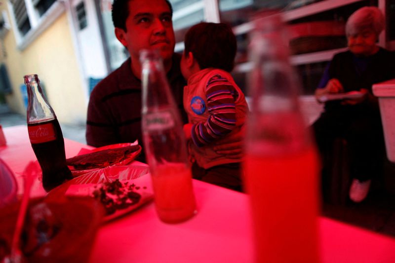 &copy; Reuters. FILE PHOTO: A man and a child eat next to bottled drinks at a food stand in Mexico City September 10, 2013. REUTERS/Edgard Garrido/File Photo