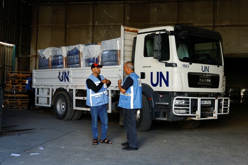 &copy; Reuters. Workers stand by a United Nations vehicle, while sorting aid to be distributed to Palestinians, as the conflict between Israel and Palestinian Islamist group Hamas continues, at a United Nations-run facility, in Khan Younis in the southern Gaza Strip, Oct