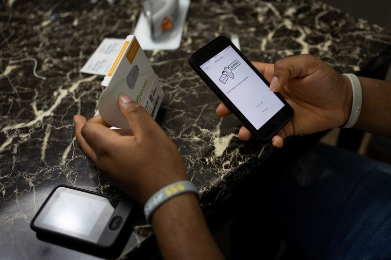 &copy; Reuters. Type 2 diabetes patient Adedotun Adebayo (15) registers his new Dexcom device, a continuous glucose monitoring system, at his home in Glenarden, Maryland, U.S., July 15, 2021. REUTERS/Hannah Beier/File photo