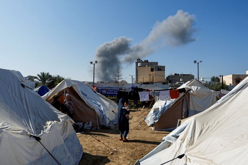 &copy; Reuters. Il fumo si leva dai vicini attacchi israeliani, visti da una tendopoli che ospita sfollati palestinesi, a Khan Younis, nel sud della Striscia di Gaza, 26 ottobre 2023. REUTERS/Ibraheem Abu Mustafa
