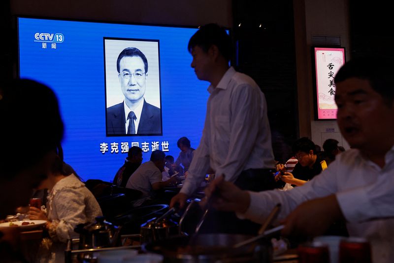 © Reuters. People dine near a screen broadcasting obituary of former Chinese Premier Li Keqiang during the evening news, following his death, at a restaurant in Beijing, China October 27, 2023. REUTERS/Tingshu Wang