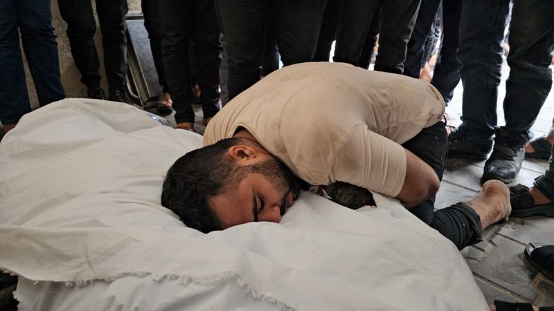 &copy; Reuters. Palestino diante de corpo da mulher em Gaza
 27/10/2023   REUTERS/Anas al-Shareef