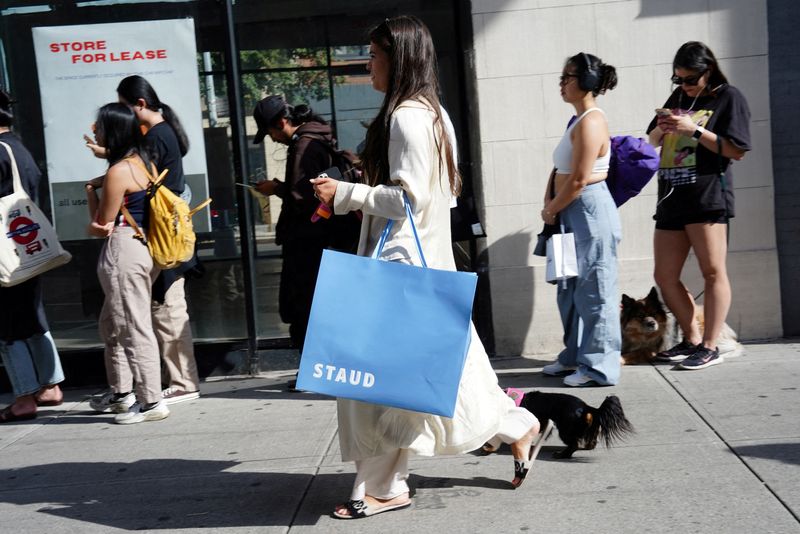&copy; Reuters. FILE PHOTO: A woman carrying a shopping bag from Staud walks past people queuing for a pop-up shop in the SoHo neighborhood of New York City, U.S., September 21, 2023.  REUTERS/Bing Guan/File Photo