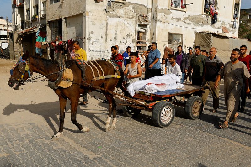 &copy; Reuters. أشخاص ينقلون جثامين فلسطينيين قتلوا جراء القصف الإسرائيلي على خان يونس بجنوب غزة على عربة يجرها  حصان يوم الجمعة . تصوير : إبراهيم أبو مصطفى -