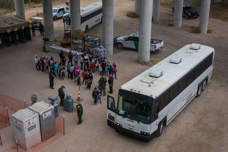 © Reuters. FILE PHOTO: Asylum seeking migrant families from Central America line up to be transported from a make shift U.S. Customs and Border Protection processing center under the Anzalduas International Bridge after crossing the Rio Grande river into the United States from Mexico in Granjeno, Texas, U.S., March 24, 2021. Picture taken with a drone. REUTERS/Adrees Latif/File Photo