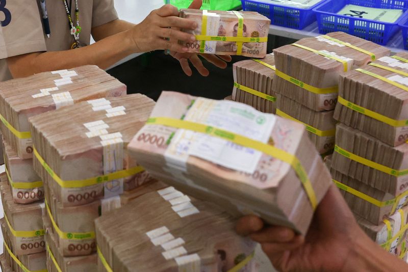 &copy; Reuters. Bank employees gather Thai baht notes at a Kasikornbank in Bangkok, Thailand, January 26, 2023. REUTERS/Athit Perawongmetha