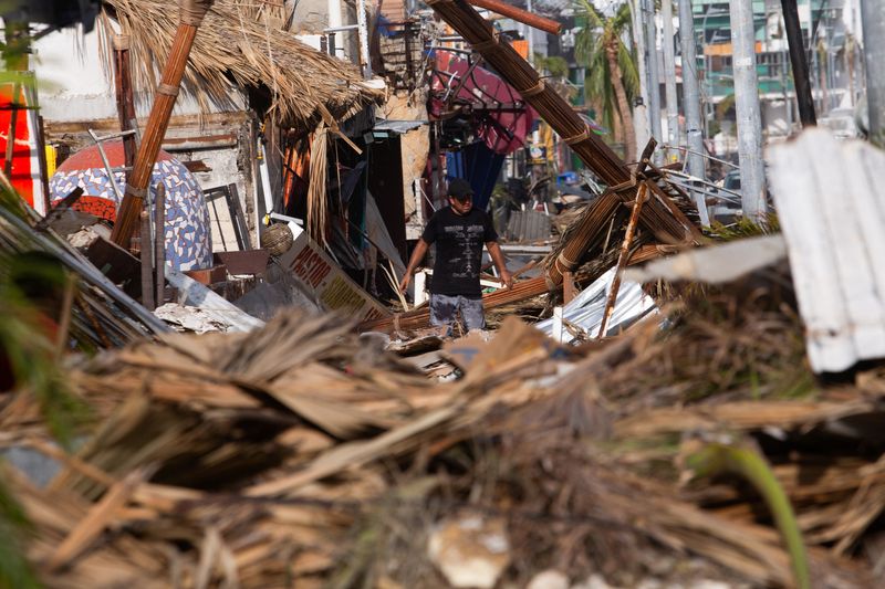 © Reuters. A man walks among rubble, in the aftermath of Hurricane Otis, in Acapulco, Mexico, October 28, 2023. REUTERS/Quetzalli Nicte-Ha